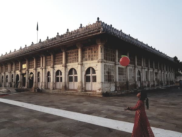 A young girl plays with a red ball outside the historic Sidi Saiyyed Mosque in Ahmedabad, India.
