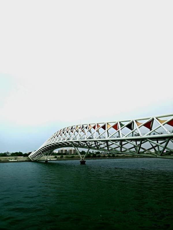 Modern steel truss bridge spanning the Sabarmati River in Ahmedabad, India on a clear day.