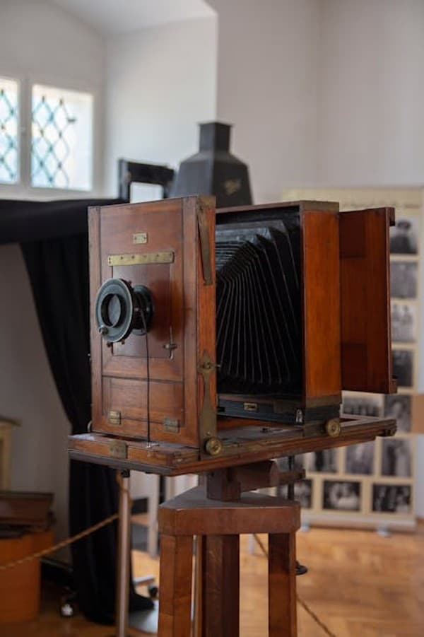 Antique wooden box camera on display in a museum, showcasing photographic history.