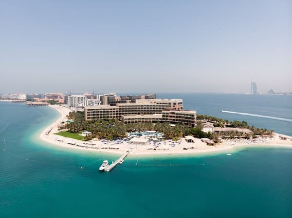 Stunning aerial shot of a luxury hotel on Dubai's Palm Jumeirah island, surrounded by turquoise waters. Stunning aerial shot of a luxury hotel on Dubai's Palm Jumeirah island, surrounded by turquoise waters.