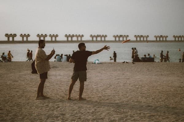 People enjoying a frisbee game at JBR Beach in Dubai during a warm day. People enjoying a frisbee game at JBR Beach in Dubai during a warm day.
