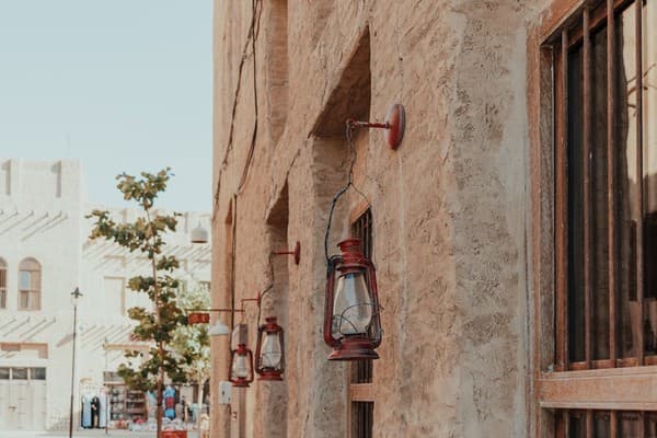 Red lanterns adorn a stone wall in Dubai's Al Seef, showcasing traditional Middle Eastern architecture. Red lanterns adorn a stone wall in Dubai's Al Seef, showcasing traditional Middle Eastern architecture.