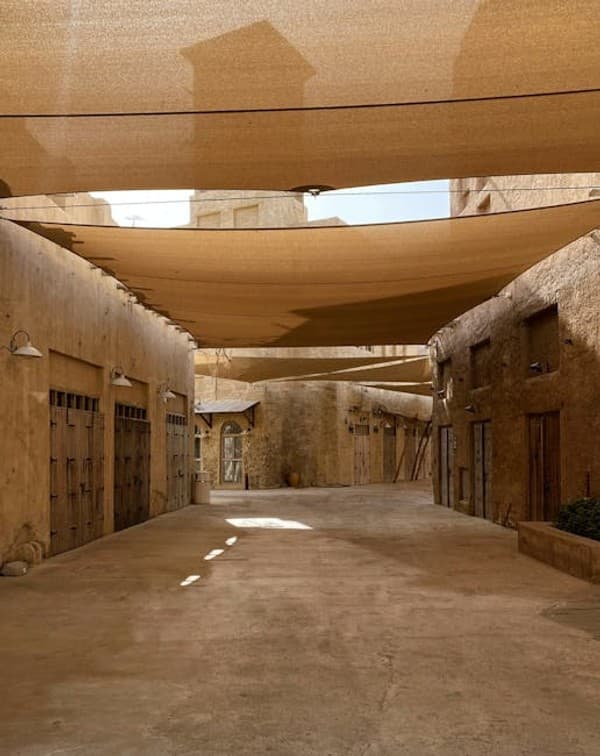 Serene view of Al Seef's heritage alleyways under sunlight filtering through sail shades. Serene view of Al Seef's heritage alleyways under sunlight filtering through sail shades.
