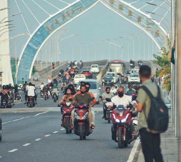 a group of people ride motorcycles under a bridge a group of people ride motorcycles under a bridge