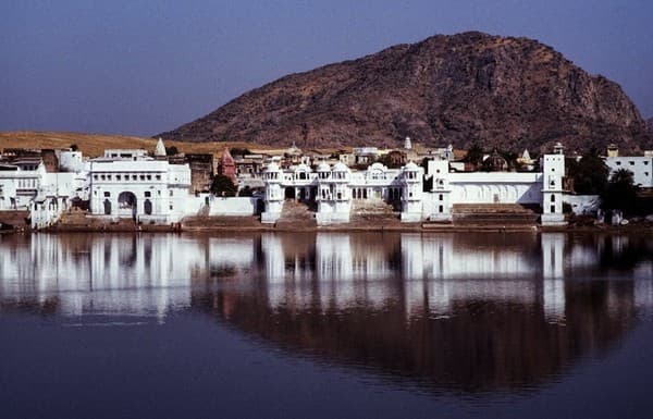Reflective view of Pushkar Lake with surrounding architecture and hills in India. Reflective view of Pushkar Lake with surrounding architecture and hills in India.